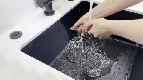 Wash vegetable process. Hand cleaning fresh carrot under faucet water on co.. Stock Footage 320706472