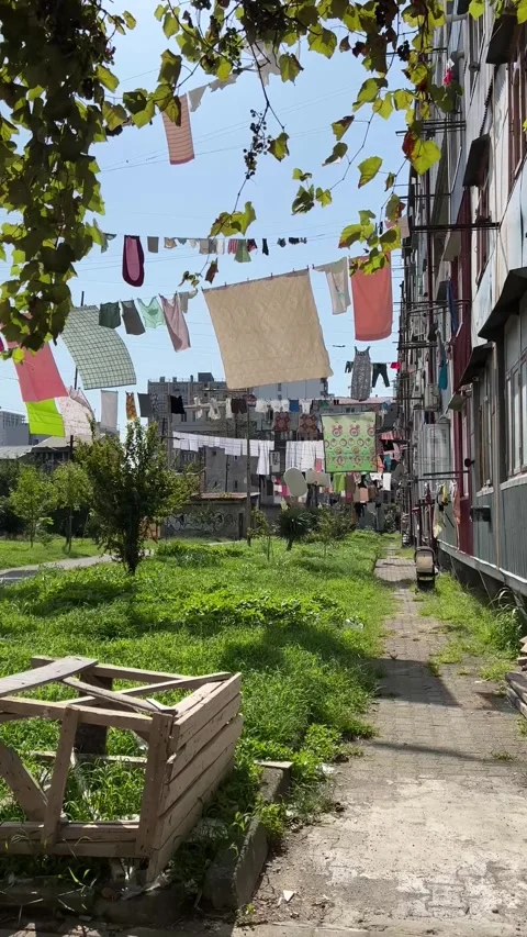 Washed clean clothes are dried in Georgian courtyard outside on rope Stock Footage 252459874
