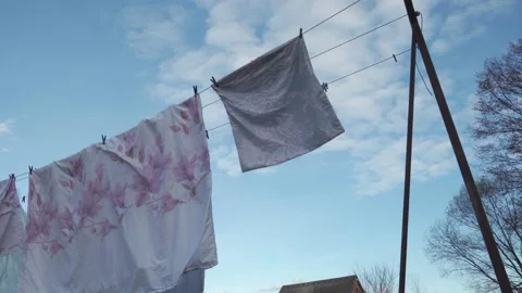Washed, clean linen hangs on a clothesline, against the background of a blue  Stock Footage 181590548