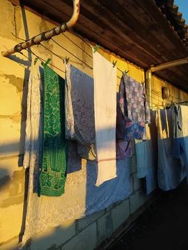 Washed clothes dry on clotheslines outside in the village in the sun Stock Photos