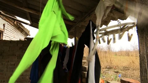 Washed old laundry dries on the wire under the roof Stock Footage 124594040