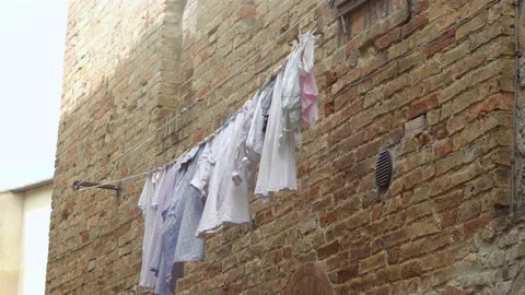 Washed things are drying on lines stretched along the wall. Stock Footage 136771679