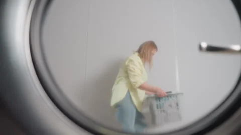 Washer Door Reflection Shows Homemaker Dancing Past With Laundry Basket 스톡 동영상 318843804