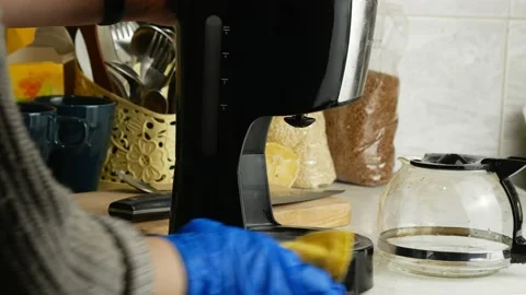 Washes the coffee maker.Gloved hands and a yellow microfiber cloth. Stock Footage 143522112
