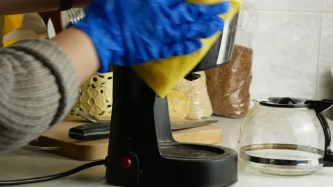 Washes the drip coffee maker.Gloved hands and a yellow napkin. Stock-Footage 143625009