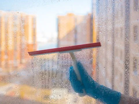 Washes the glass of a large window. Stock Photos