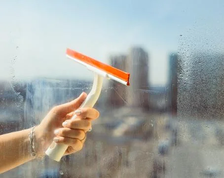 Washes the glass of a large window. Stock Photos