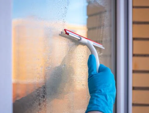 Washes the glass of a large window. Stock Photos