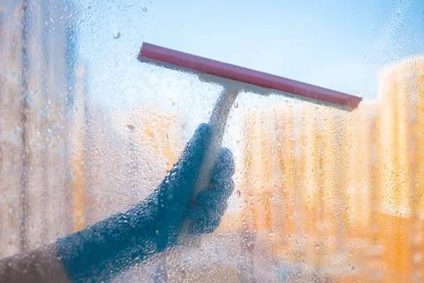 Washes the glass of a large window. Stock Photos