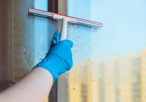 Washes the glass of a large window. Stock Photos