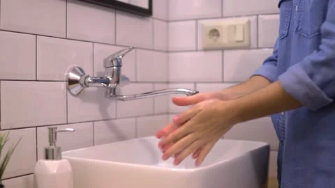 Washes hands in the bathroom sink with liquid antibacterial soap Stock Footage 225052563
