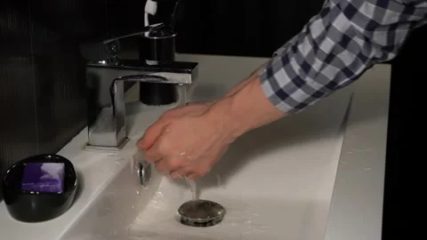 Washes his hands in the sink Video stock 142907454
