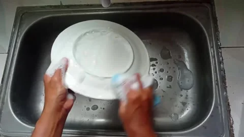 Washes a plate using dishwashing liquid Stock Footage 322900452