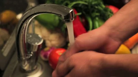 Washing Assorted Vegetables in Kitchen Sink Stock Footage 343738476
