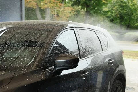Washing auto with high pressure water jet at outdoor car wash Stock Photos