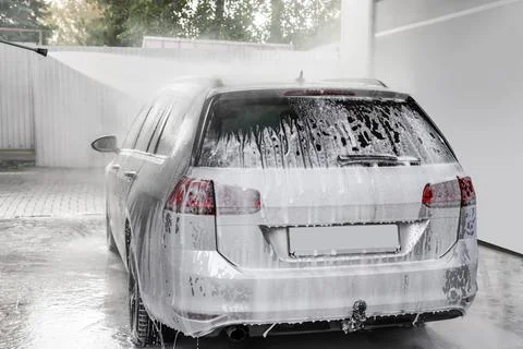 Washing auto with high pressure water jet at outdoor car wash Stock Photos
