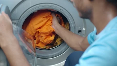 Washing bright clothes in the laundry machine Vídeo Stock 344917741