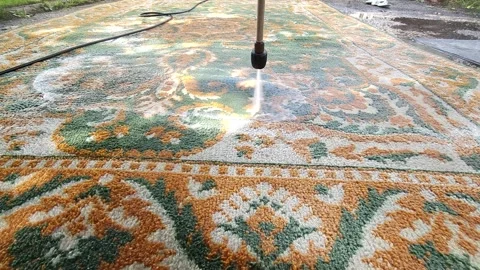 Washing carpets with a high-pressure machine with detergents in the yard Stock Footage 247437550
