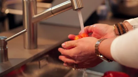 Washing cherry tomatoes by hand in the kitchen Stock Footage 149118634