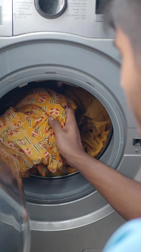 Washing clothes in the laundry machine at home Stock Footage 340543515
