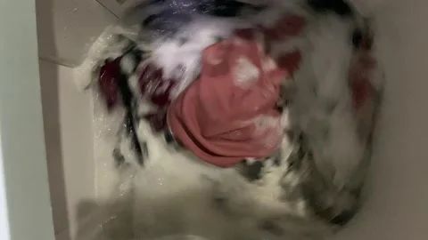 Washing clothes process inside top load washing machine Stock Footage 312392715