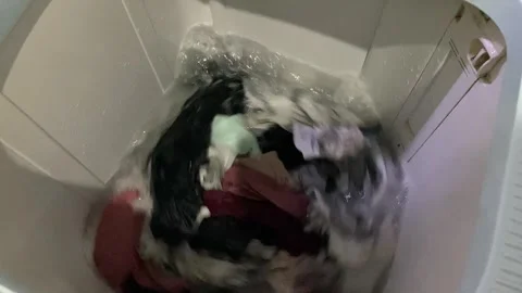 Washing clothes process inside top load washing machine Stock Footage 312398923