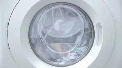 Washing clothes process. Washing machine working with laundry, close up Stock Footage 231582245
