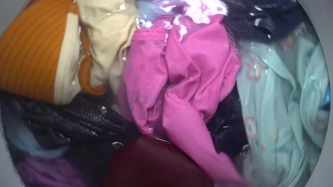Washing clothes in a top loader washing machine Stock Footage 286973443