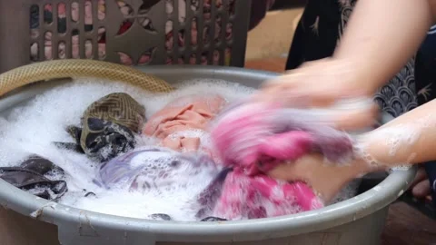 Washing clothes using detergent in a plastic tub Stock Footage 343254527