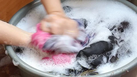 Washing clothes using detergent in a plastic tub Stock Footage 343254529