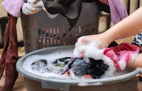 Washing clothes using detergent in a plastic tub Stock Photos