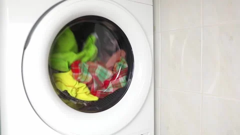 Washing colored clothes in washing machine. automatic washer in operation Stock Footage 233820853