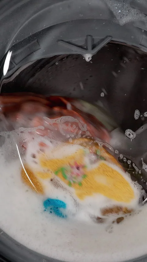 Washing Colored Laundry In A Washing Machine, Spinning Colorful Items Through A  Video stock 270310693