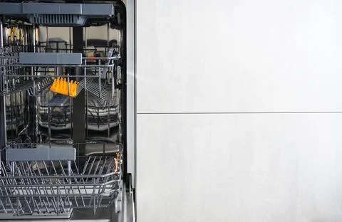 Washing dishes in the dishwasher. An open, empty dishwasher with meta for tex Foto stock