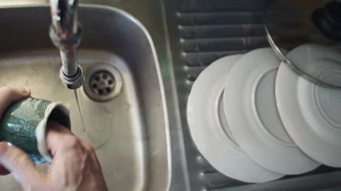 Washing the dishes by hand by the sink Stock Footage 333330800
