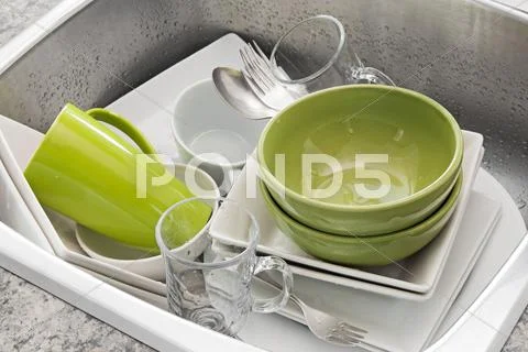 Washing dishes in the kitchen sink Stock Photos