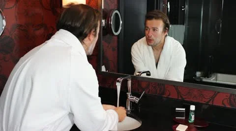 Washing face in front of mirror V2 - HD Video stock 12235684