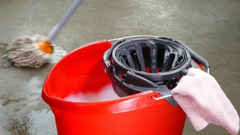 Washing a floor using a mop and a bucket of soapy water. Video stock 122035742