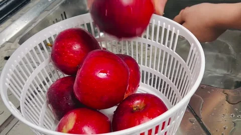 Washing fresh red apples and placing in colander Stock Footage 337727500