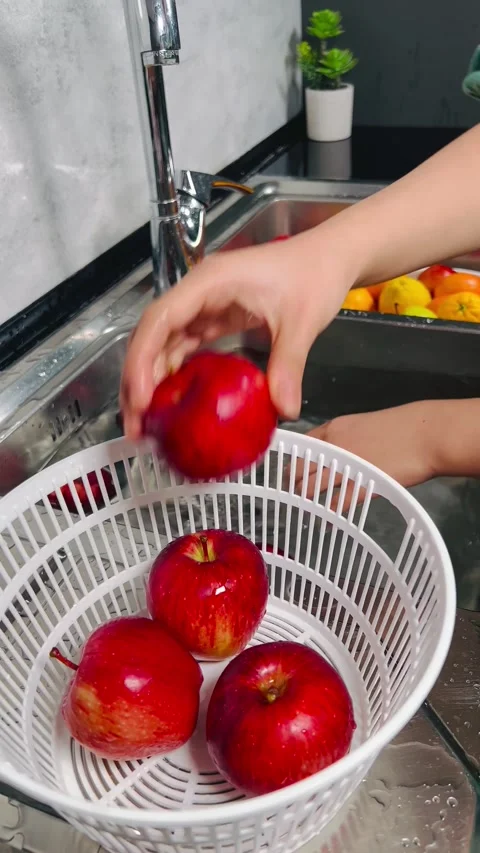 Washing fresh red apples in the kitchen sink Vídeos de archivo 336136128