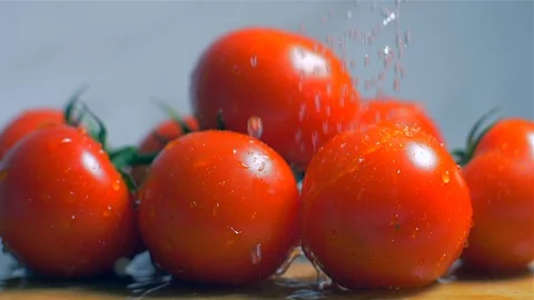 Washing fresh tomato on a wooden board in a slow motion Vídeo Stock 105132353