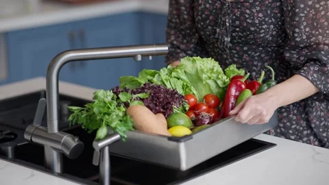 Washing fresh vegetables in a kitchen sink Stock Footage 336466183