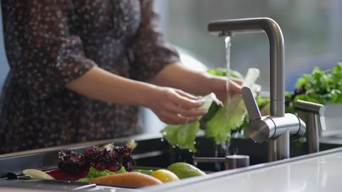 Washing fresh vegetables in a kitchen sink Stock Footage 336466190