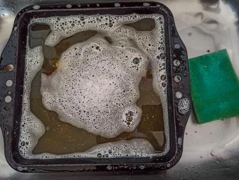 Washing Greasy Baking Sheets with Soap Foam Stock Photos
