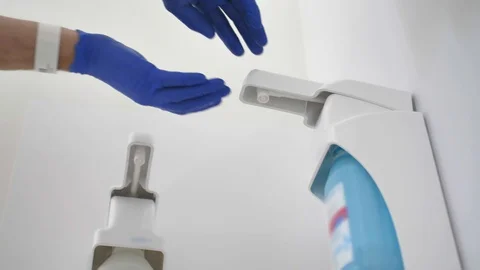 Washing Hands in Blue Gloves Using Hand Sanitizer to Disinfect Virus Stock Footage 128839960