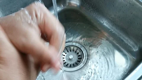 Washing hands at the kitchen sink Stock Footage