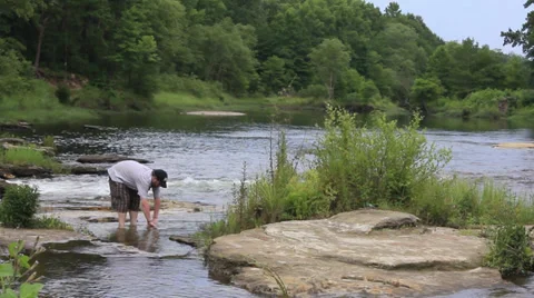 Washing hands in river Stock Footage 27338763