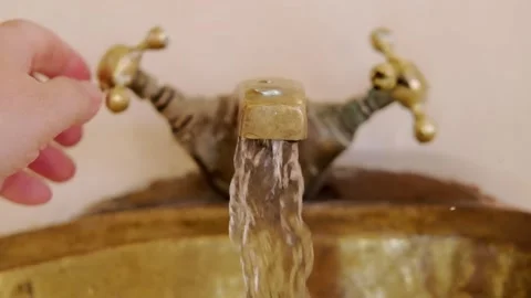 Washing hands in Rustic brass sink, morning skincare routine in Moroccan-st.. Stock Footage 305156418