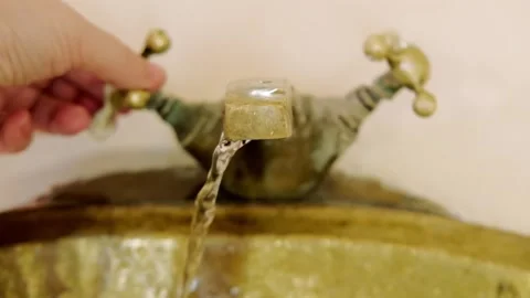 Washing hands in Rustic brass sink, morning skincare routine in Moroccan-st.. Stock Footage 327487845
