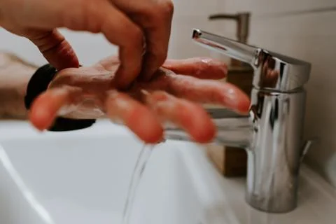 Washing hands with soap to fight covid-19 Stock Photos